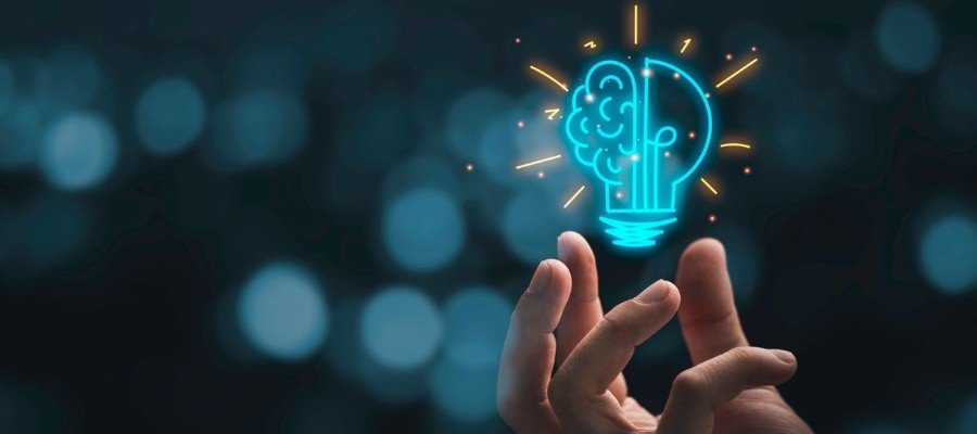 a person holding up a glowing light bulb with a brain inside to symbolize innovative lead management solutions