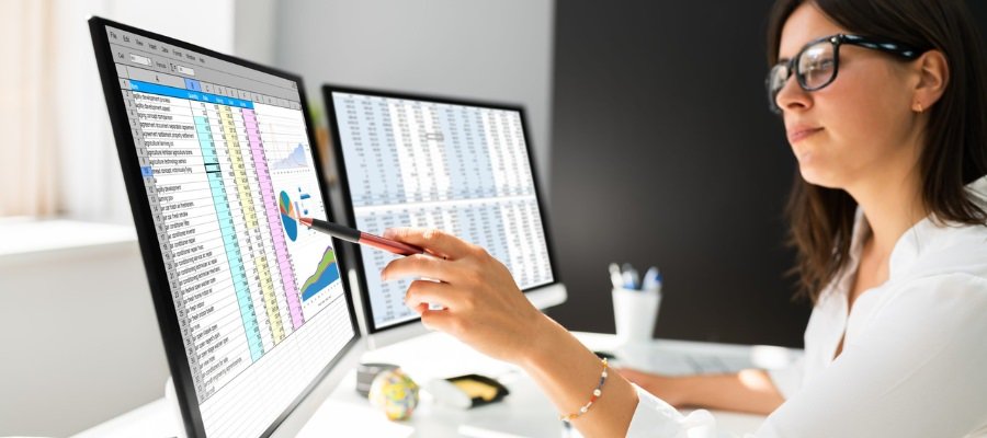 woman in glasses looking at a computer screen with a chart from a lead management tool on it